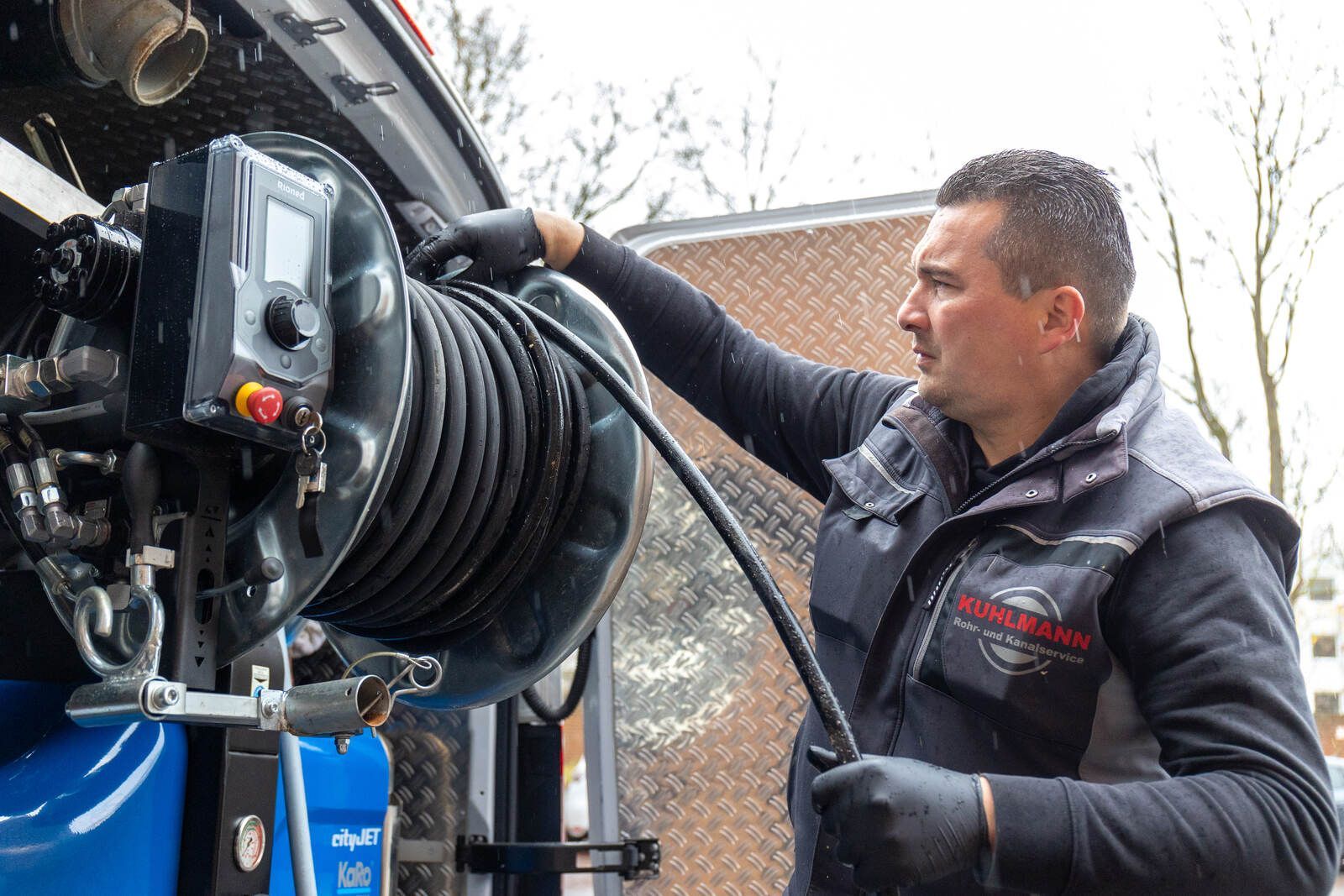 Ein Mann arbeitet an einer Maschine, an der ein Schlauch angeschlossen ist.