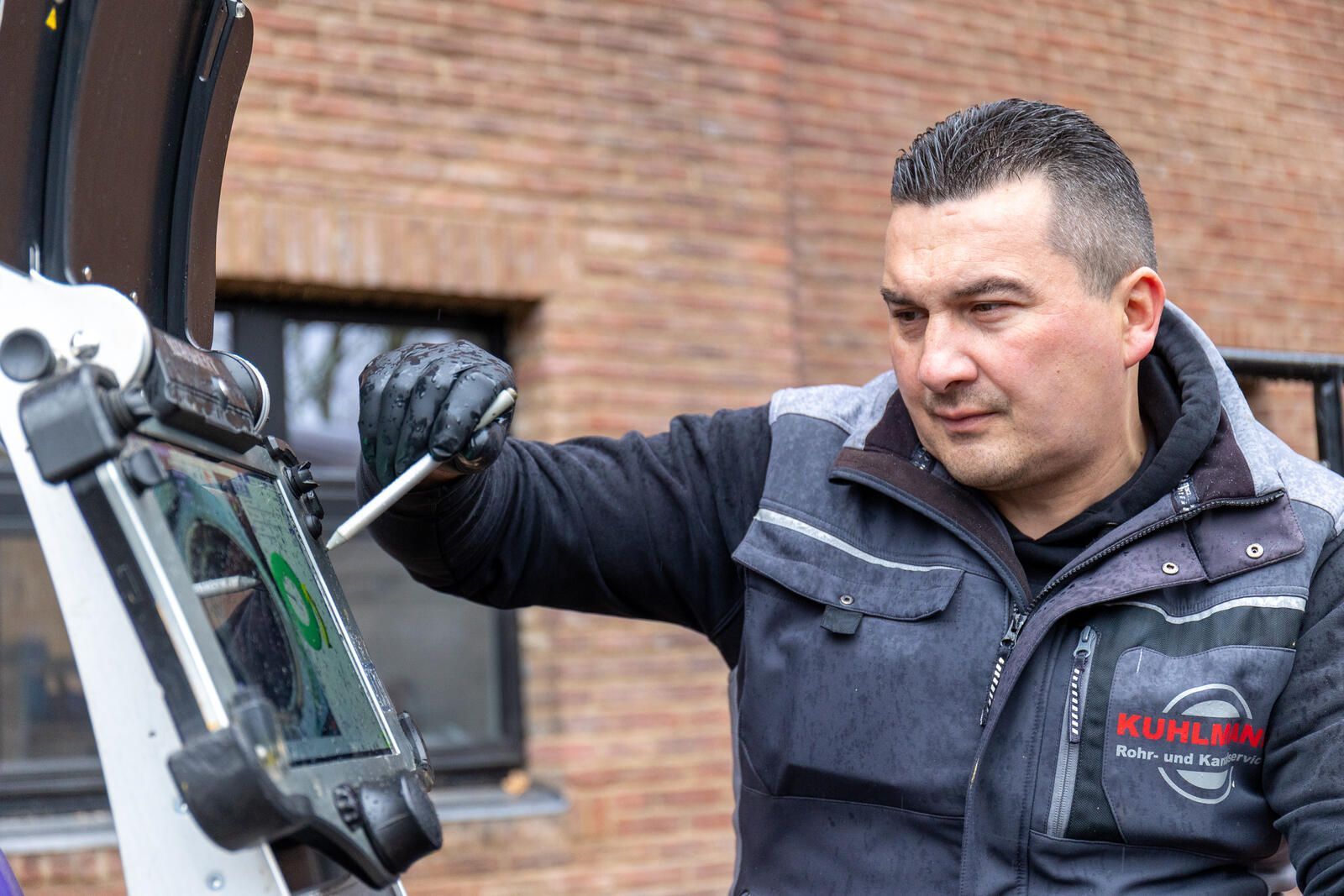 Ein Mann arbeitet mit einem Schraubenzieher an einer Maschine.