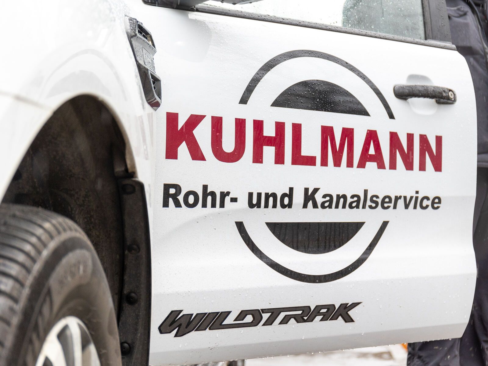 Ein weißer LKW mit dem Wort Kuhlmann Rohr- und Kanalservice auf der Tür