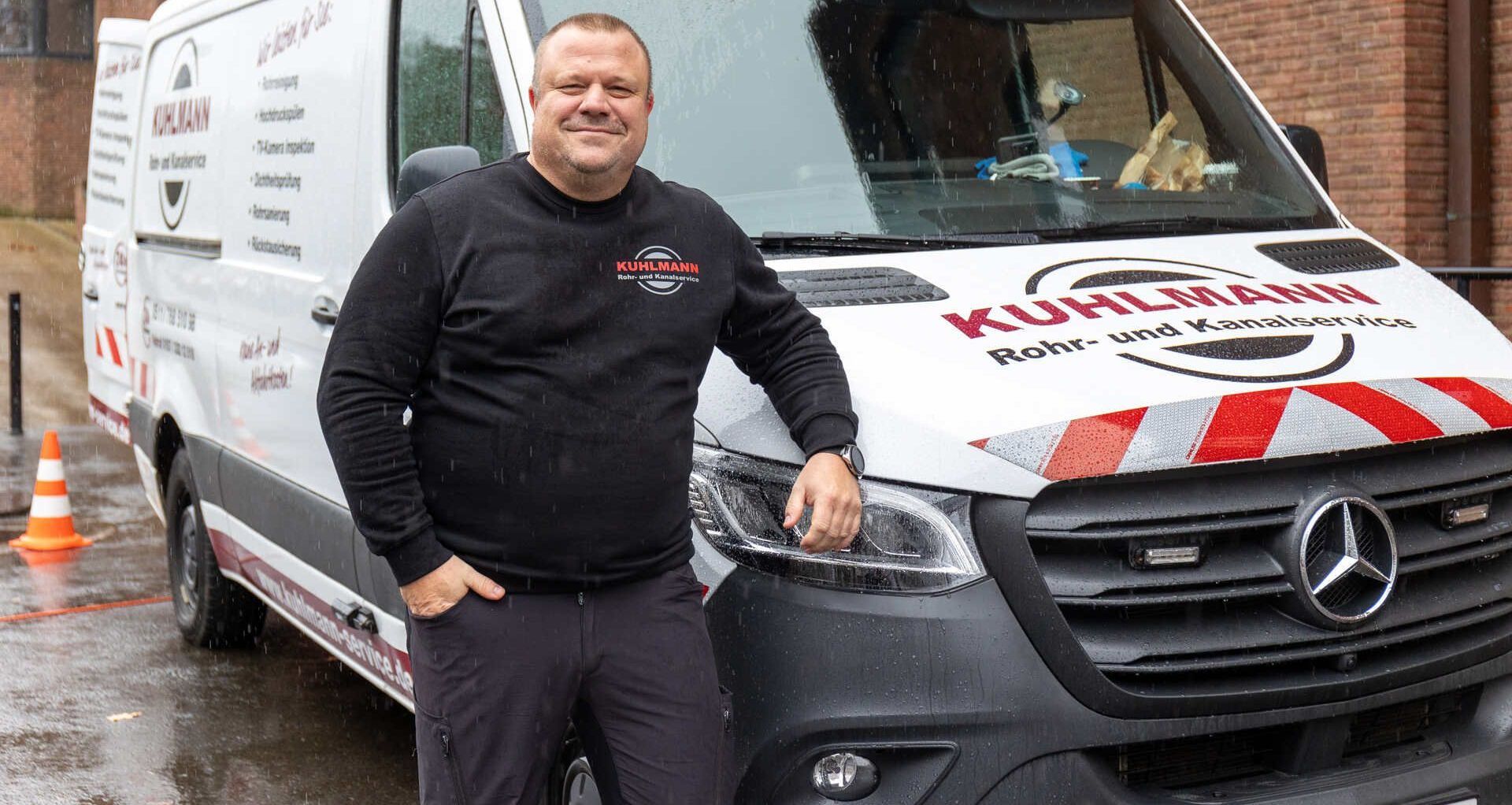 Ein Mann steht vor einem Mercedes-Van.