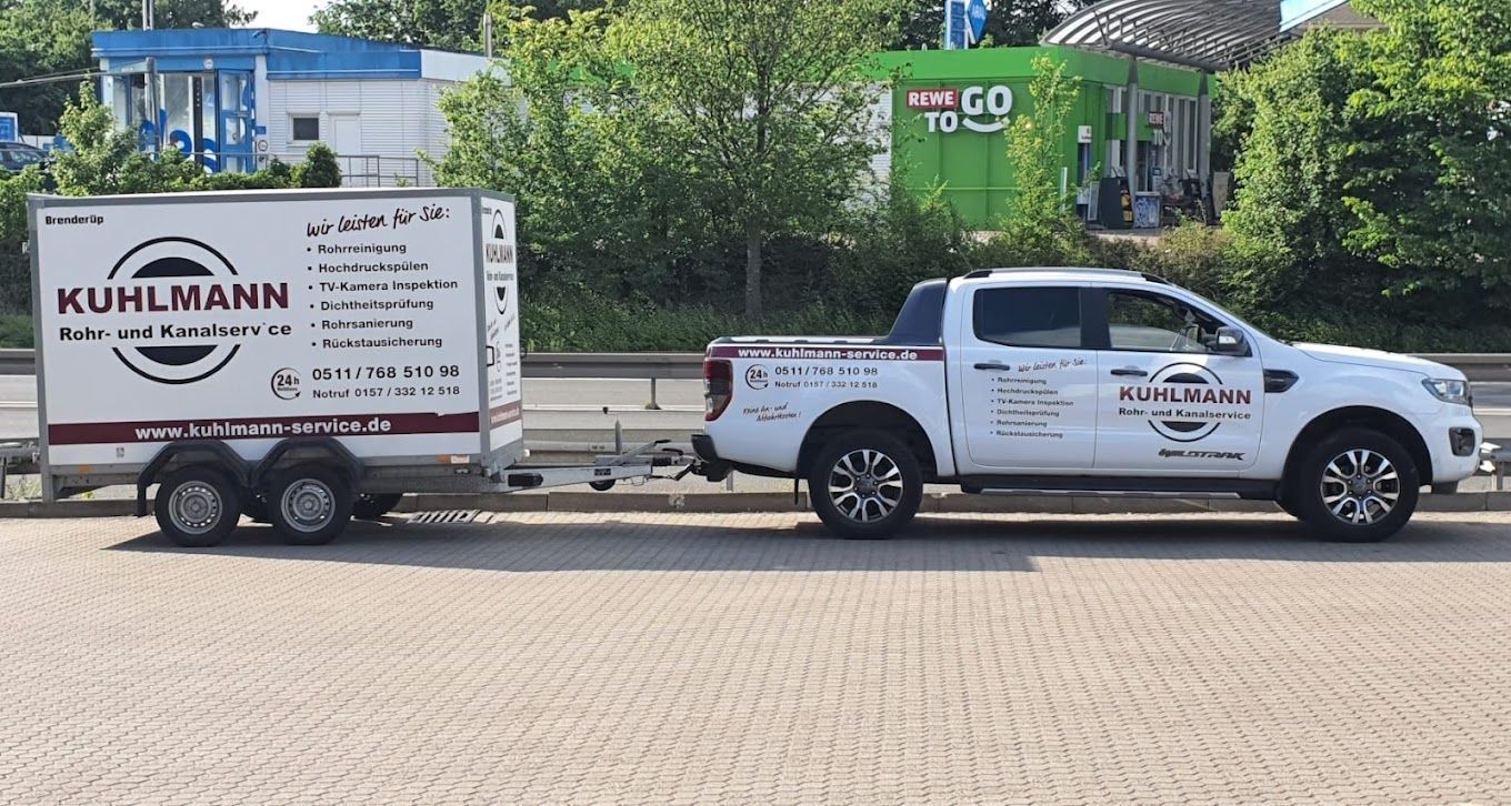 Ein weißer Lastwagen mit Anhänger steht am Straßenrand.