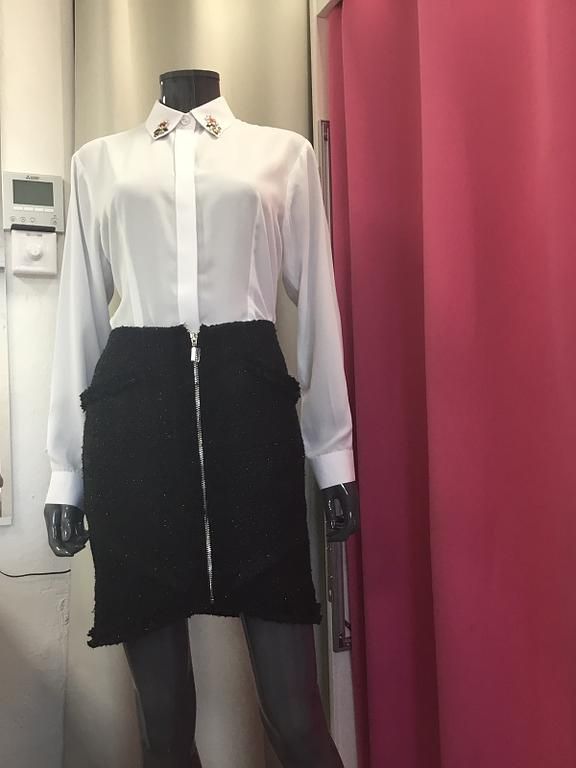 Chemisier blanc élégant avec jupe noire en tweed.