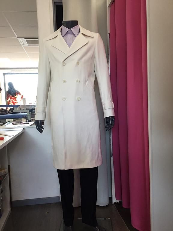  Manteau long blanc à double boutonnage avec manches longues.