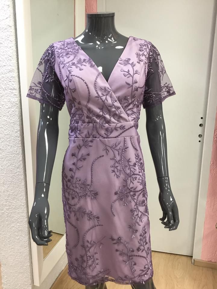 Robe parme avec manches en voile et détails brodés.

