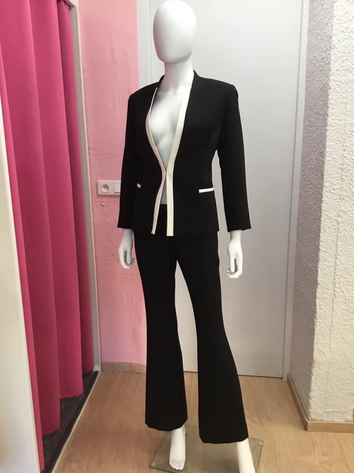 Tailleur noir classique avec bordures blanches contrastantes.