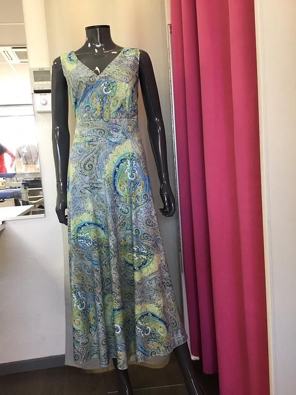 Robe longue avec un imprimé floral bleu et vert, dotée d'une coupe fluide et élégante.