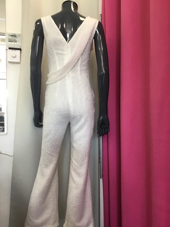 Combinaison blanche avec haut en dentelle et pantalon évasé 