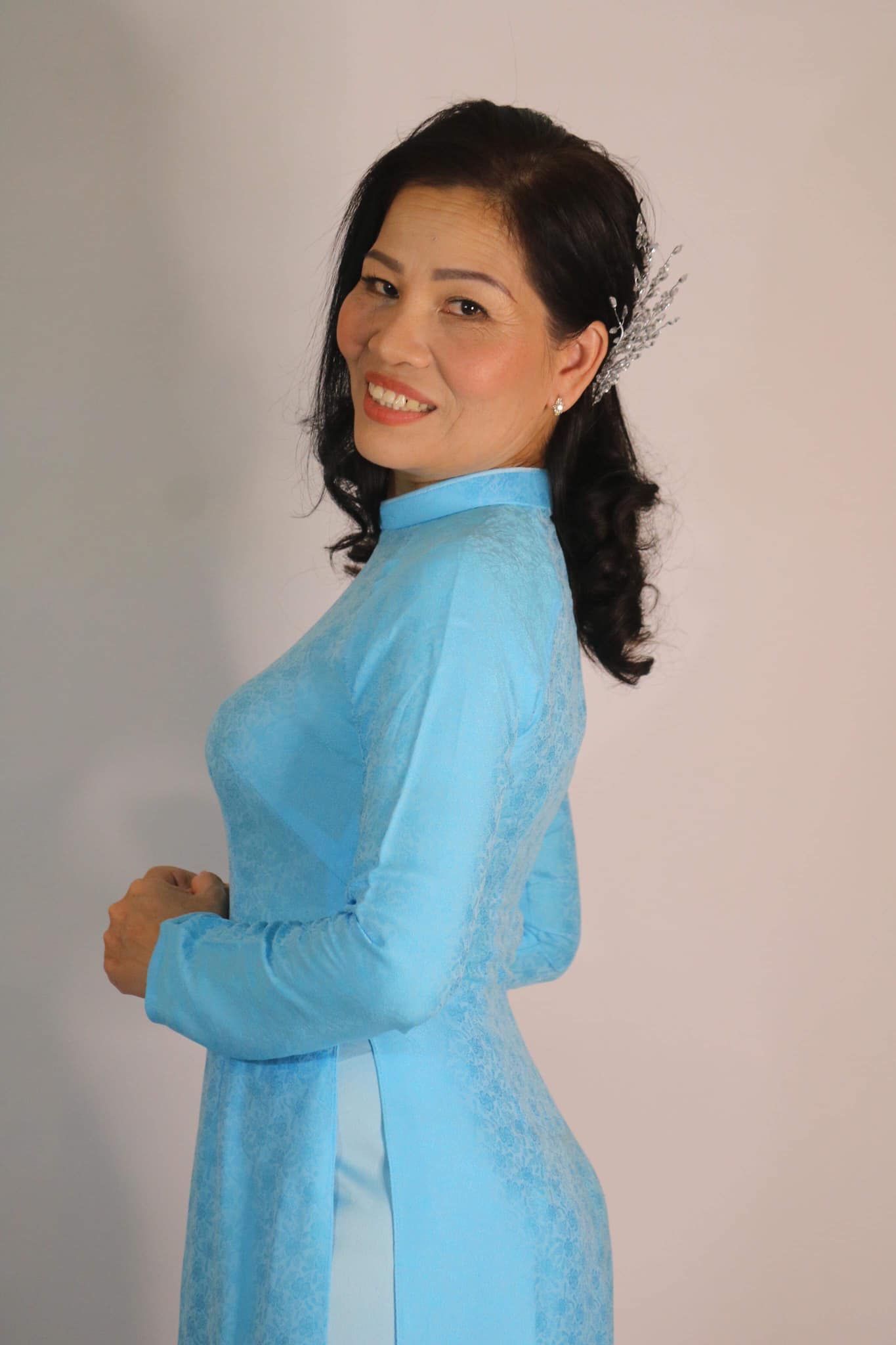 Portrait de la couturière Thi Hanh en tenue traditionnelle bleue