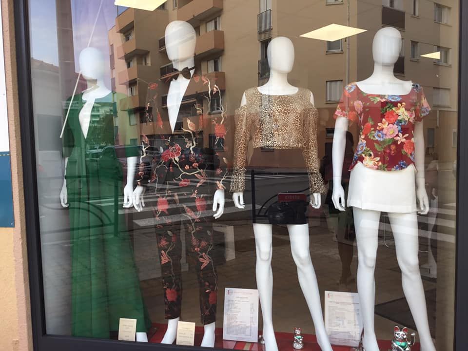 Vitrine avec mannequins portant des tenues élégantes