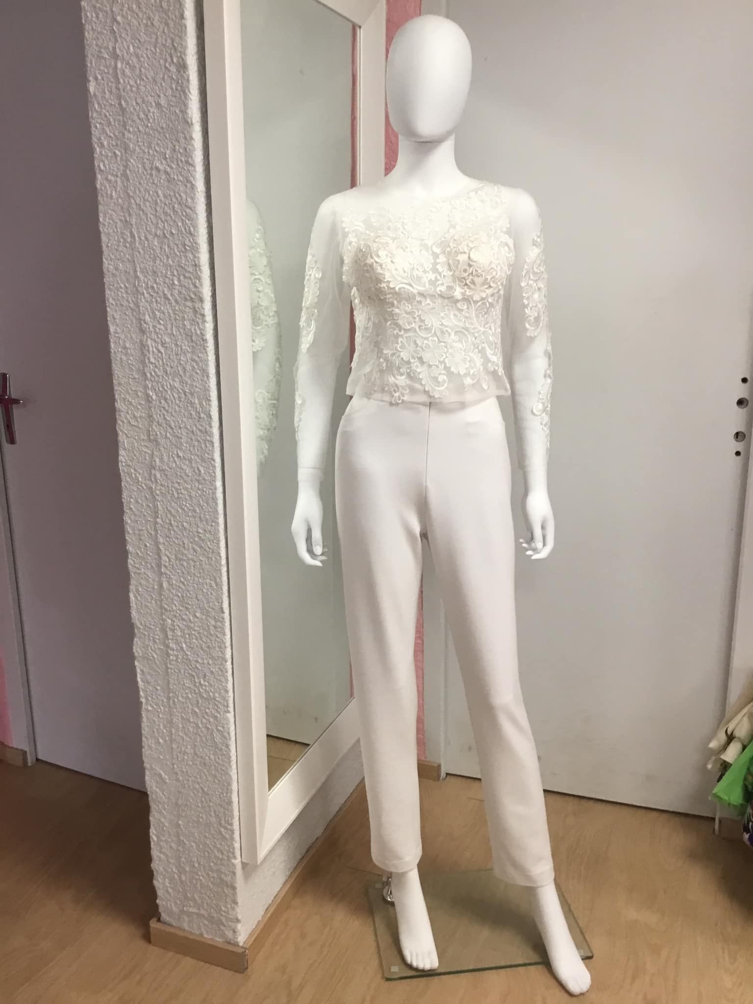 Ensemble blanc élégant avec haut en dentelle et pantalon droit