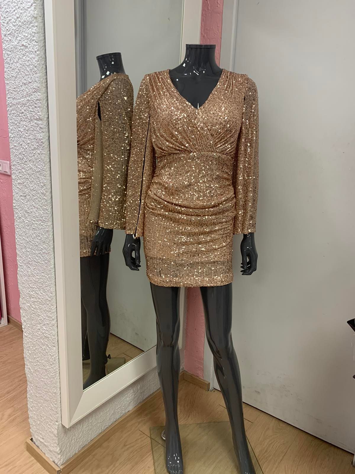 Robe courte dorée à paillettes sur mannequin