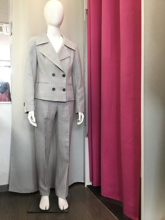 Tailleur gris clair avec une veste ajustée et un pantalon assorti, offrant une allure professionnelle et moderne.
