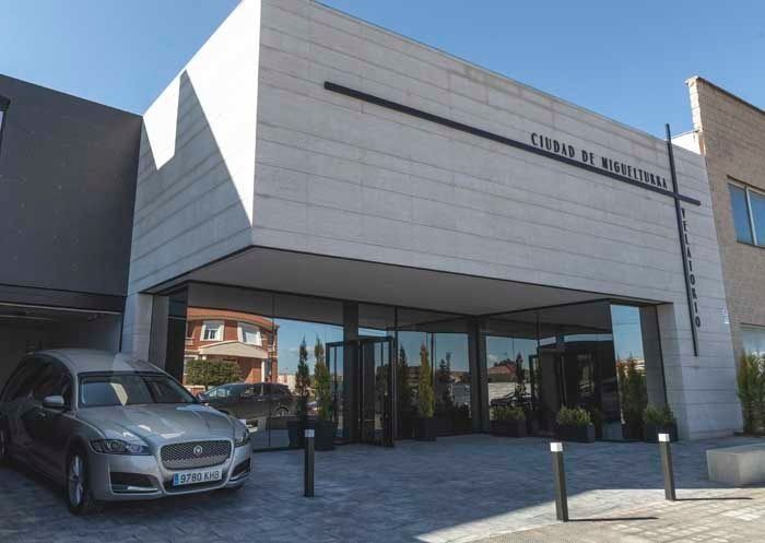 Un coche está aparcado delante de un edificio que tiene la palabra funeral.