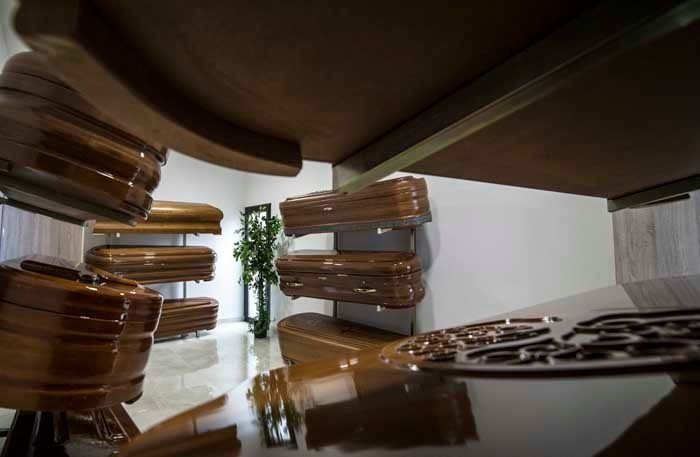 Una habitación llena de ataúdes de madera y una mesa.