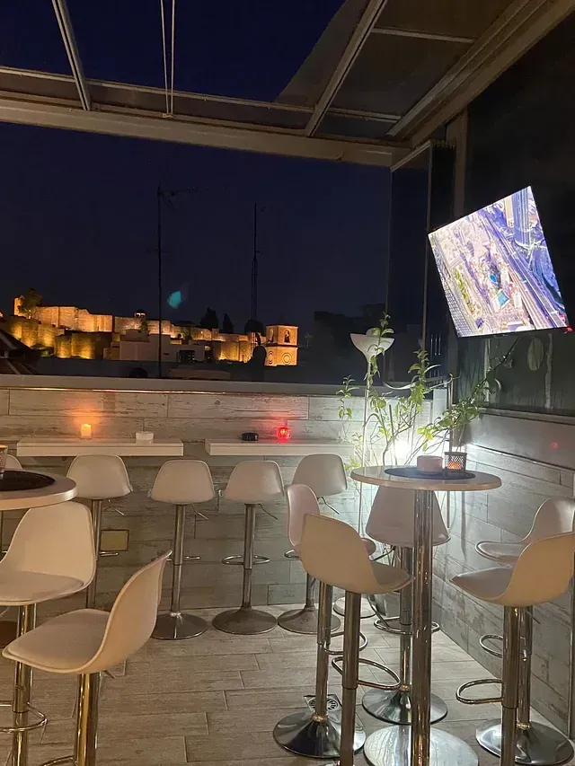 Un restaurante con mesas y sillas y un televisor en la pared.
