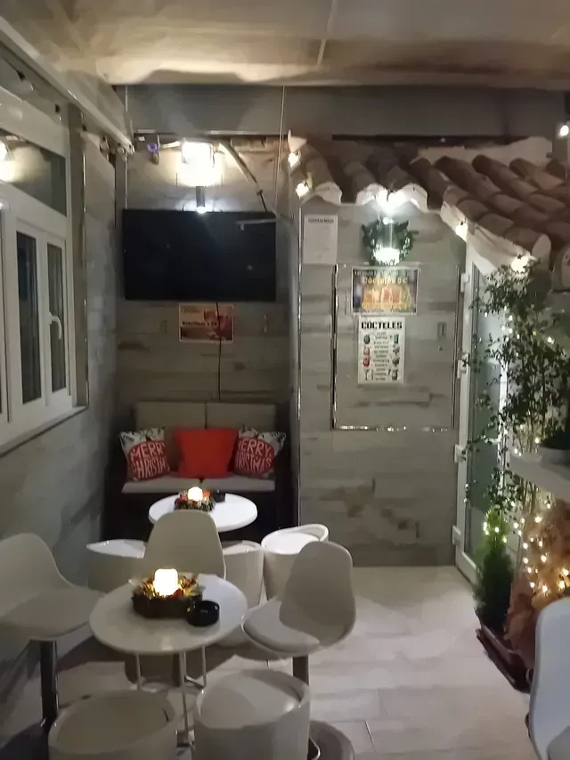 Una habitación con mesas y sillas y un sofá