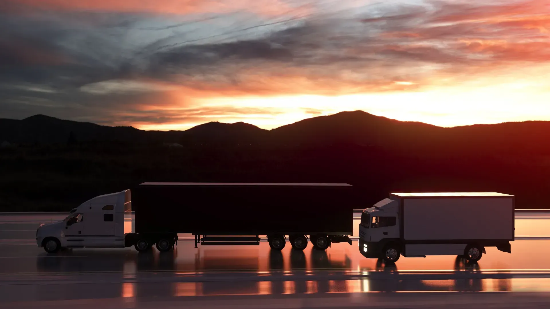 Tres camiones están estacionados en una carretera mojada al atardecer.