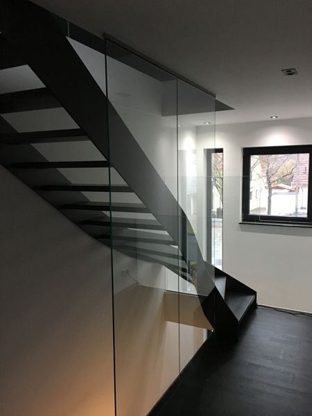 Eine Treppe mit Glasgeländer und Fenster