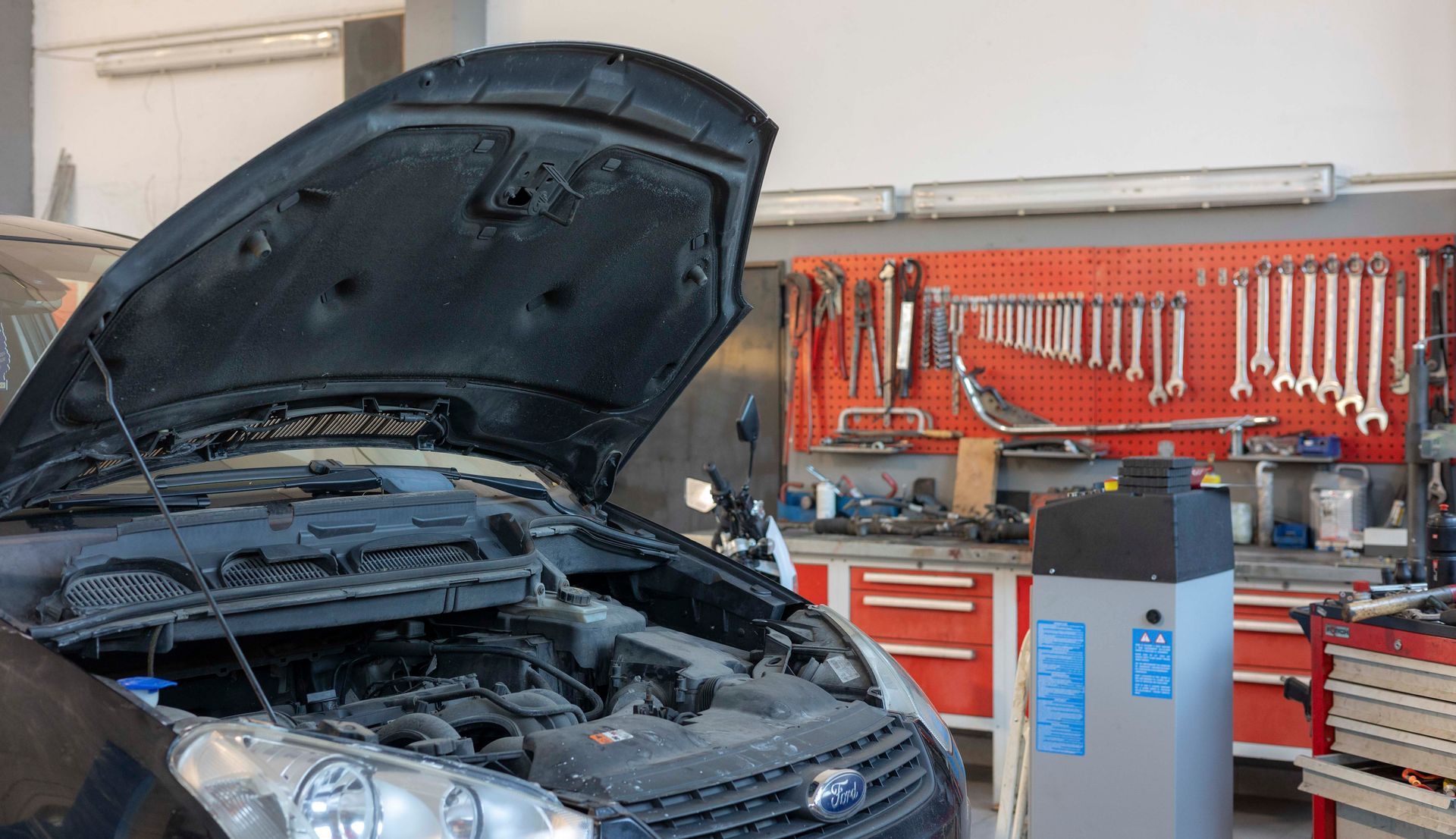 ein Auto mit offener Motorhaube in einer Garage