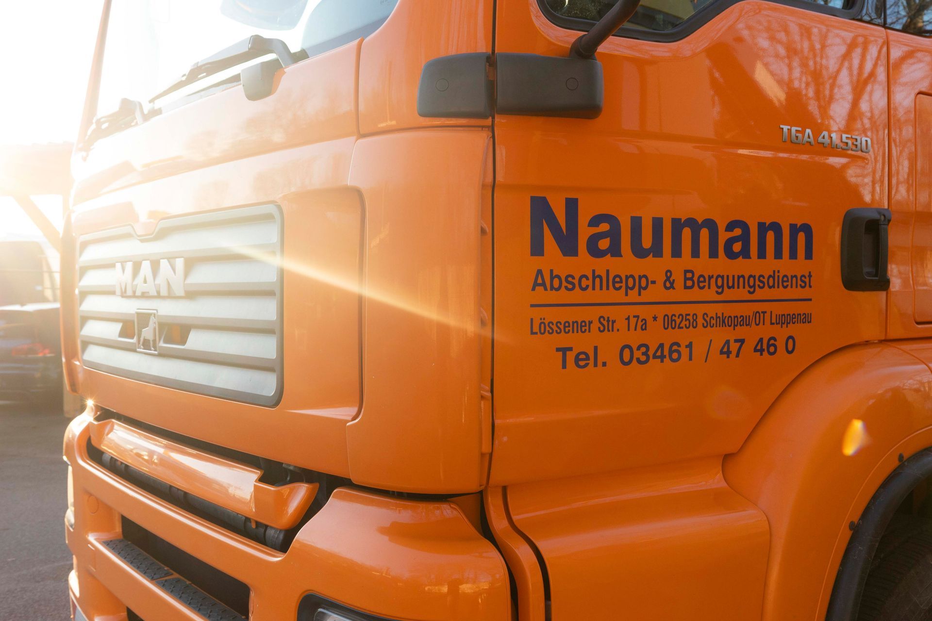 ein orangefarbener lkw mit dem schriftzug naumann