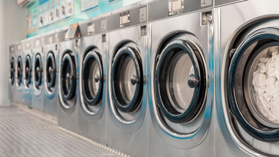 Sala de estar moderna con sofá blanco, gabinetes negros y múltiples luces colgantes.