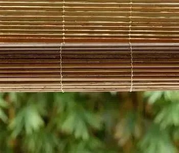Um close de uma persiana de bambu pendurada em uma janela.