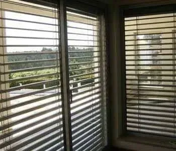 Uma sala com portas de vidro deslizantes e persianas nas janelas.