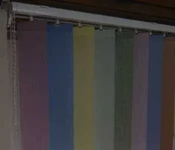 Um close de uma persiana vertical colorida em uma janela.