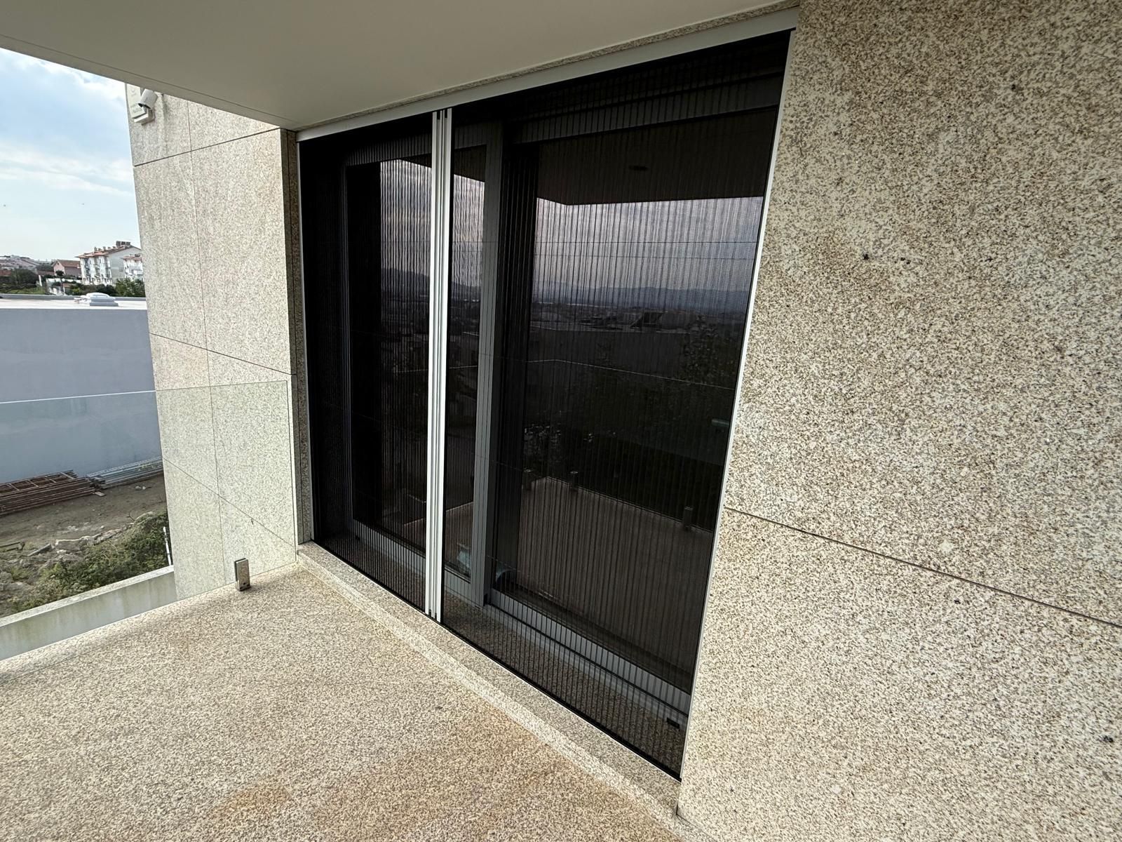 Duas persianas estão penduradas na parede, uma ao lado da outra.