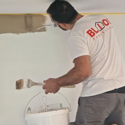 Kleines Badezimmer mit Toilette, Waschbecken, Fenster und Wänden in neutralen Farben. Schwarze Arbeitsplatte und Boden.