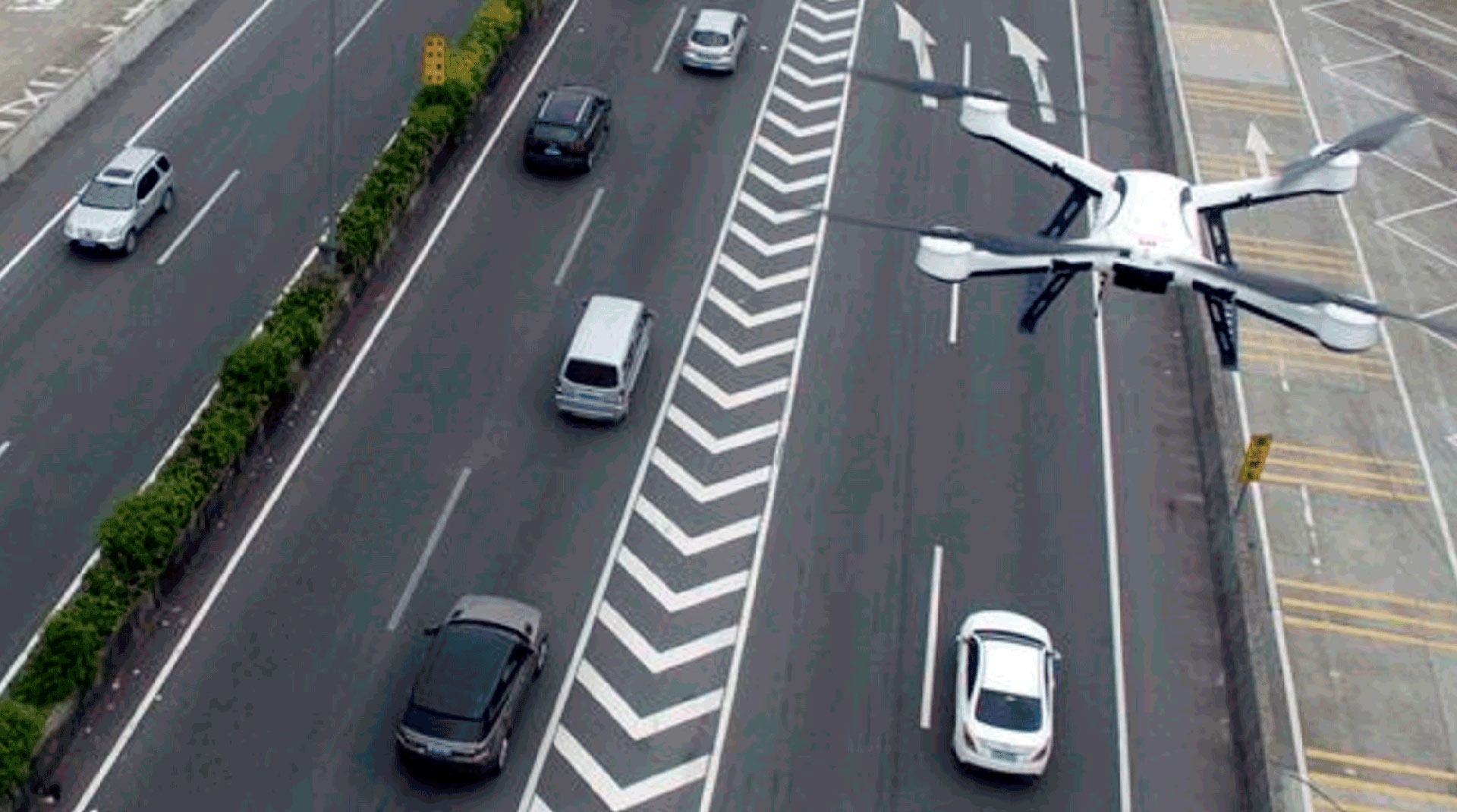 Un dron está volando sobre una autopista por la que circulan coches.