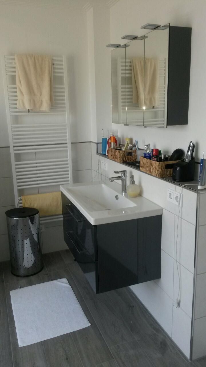 Ein Badezimmer mit Waschbecken, Spiegel und Handtuchhalter