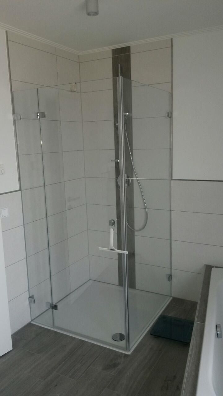 Ein Badezimmer mit ebenerdiger Dusche und Badewanne.