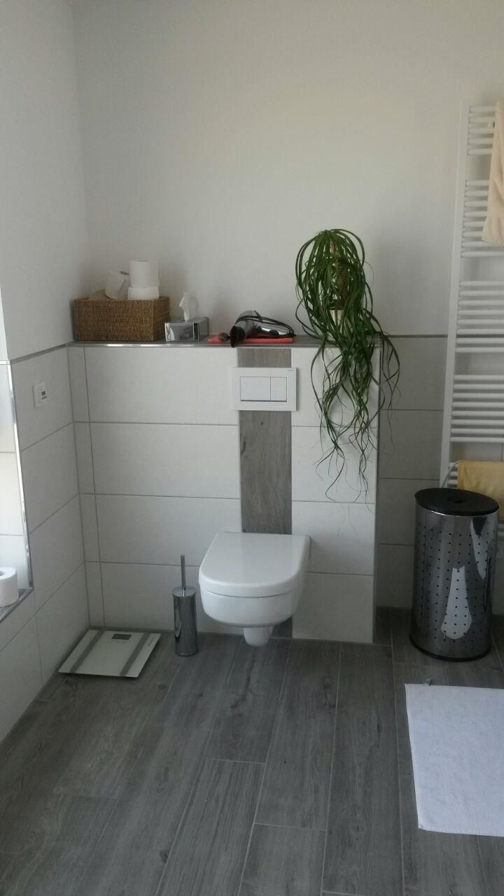 Ein Badezimmer mit Toilette und Waage auf dem Boden.