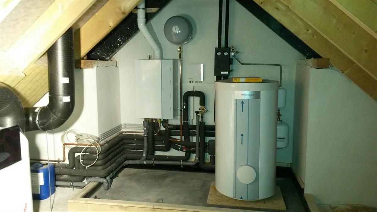 Ein Raum mit einem Heizkessel und Rohren darin