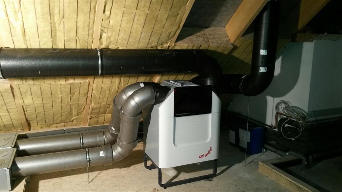 In einem Raum steht eine weiße Maschine, aus der Rohre herauskommen.