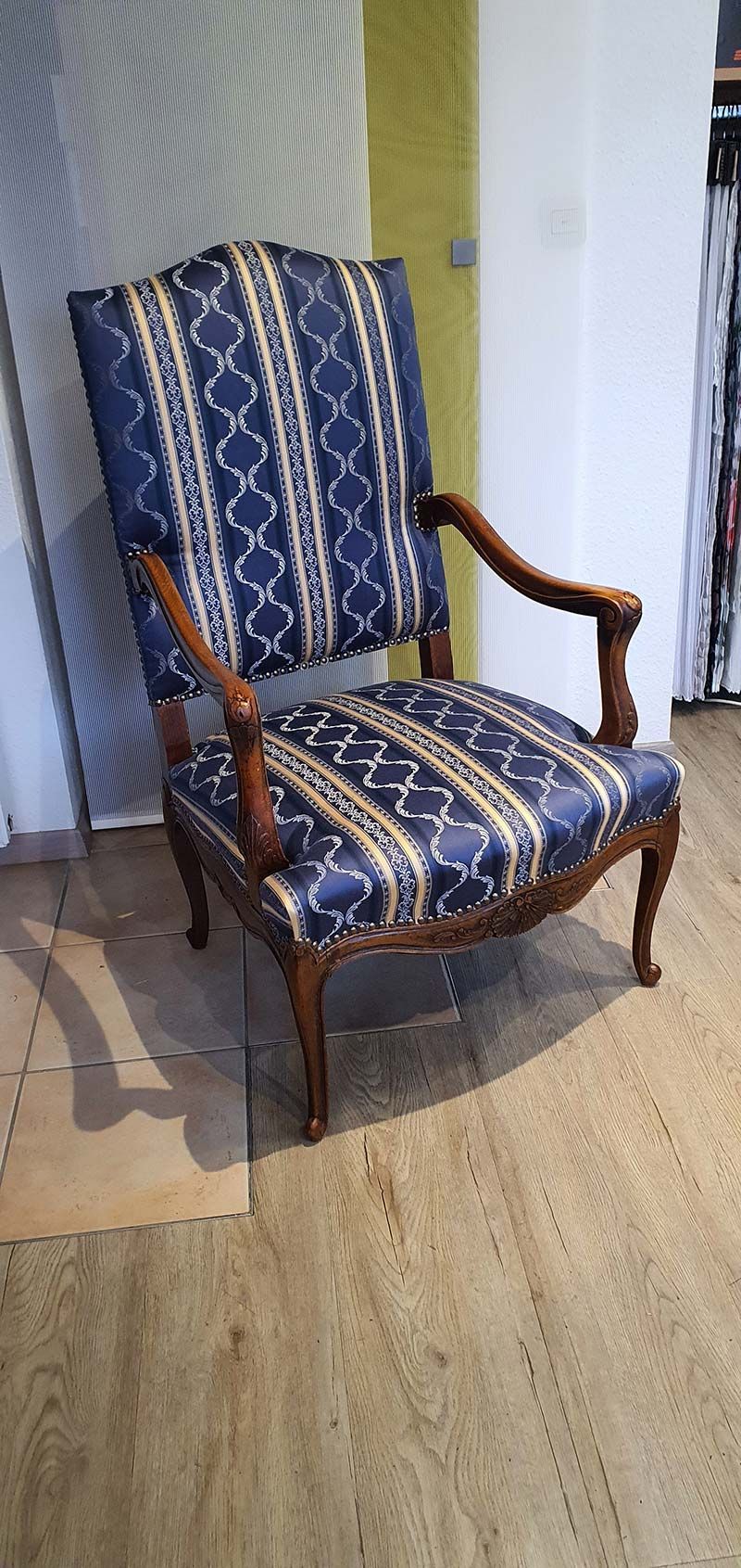 Ein blau-weiß gestreifter Stuhl steht auf einem Holzboden.