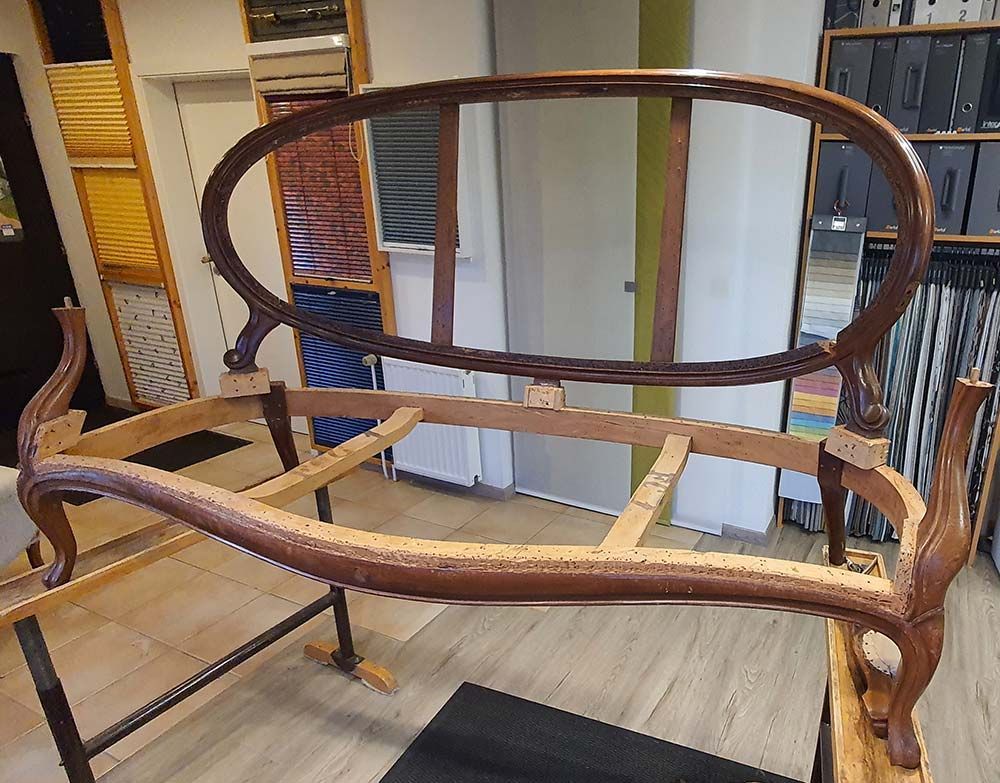 In einem Zimmer steht ein Holzsofa auf einem Holztisch.