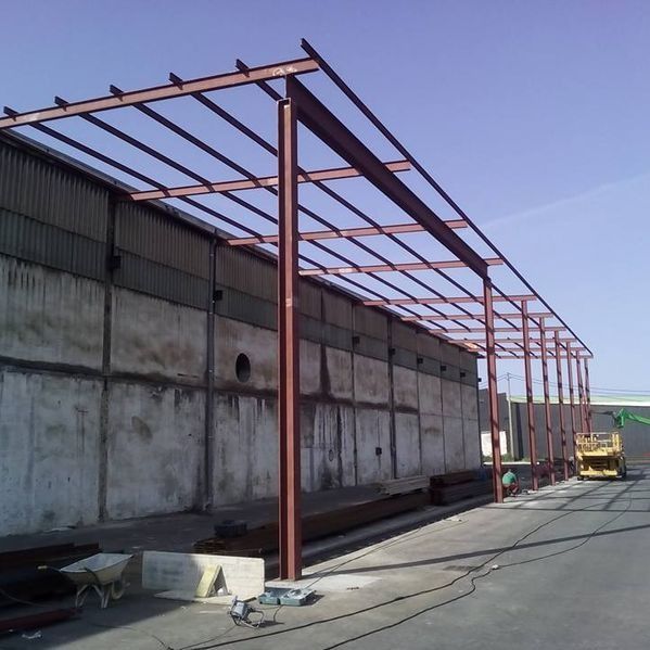 Se está construyendo una gran estructura metálica frente a un edificio.