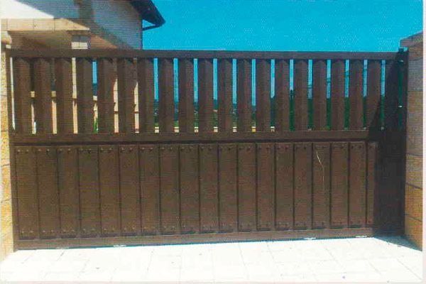 Una valla de madera con un cielo azul al fondo.