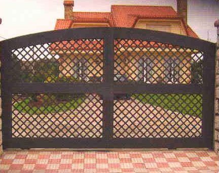 Una puerta negra está delante de una casa con techo rojo.