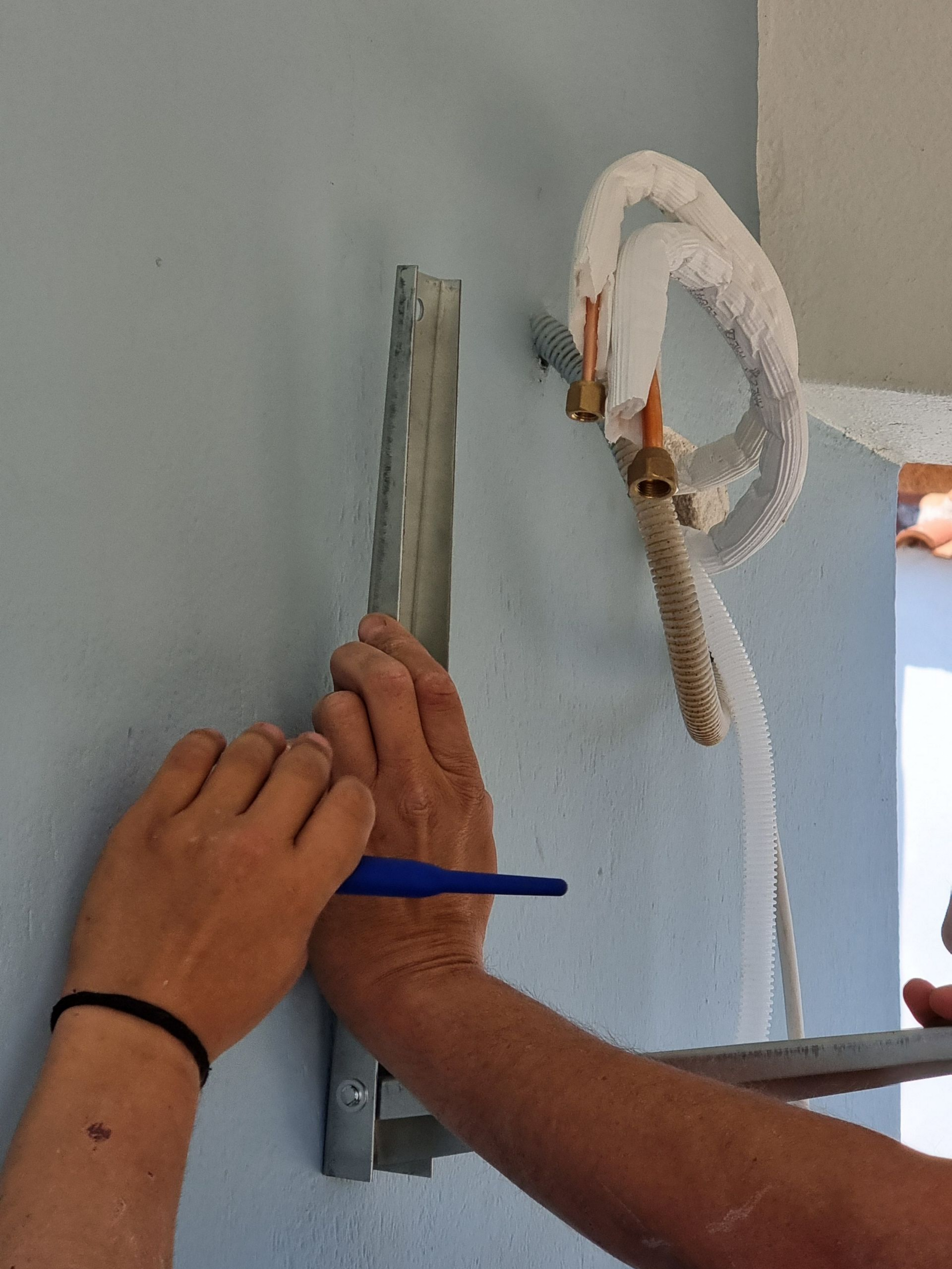 Un support mural à côté de tuyaux de climatisation.