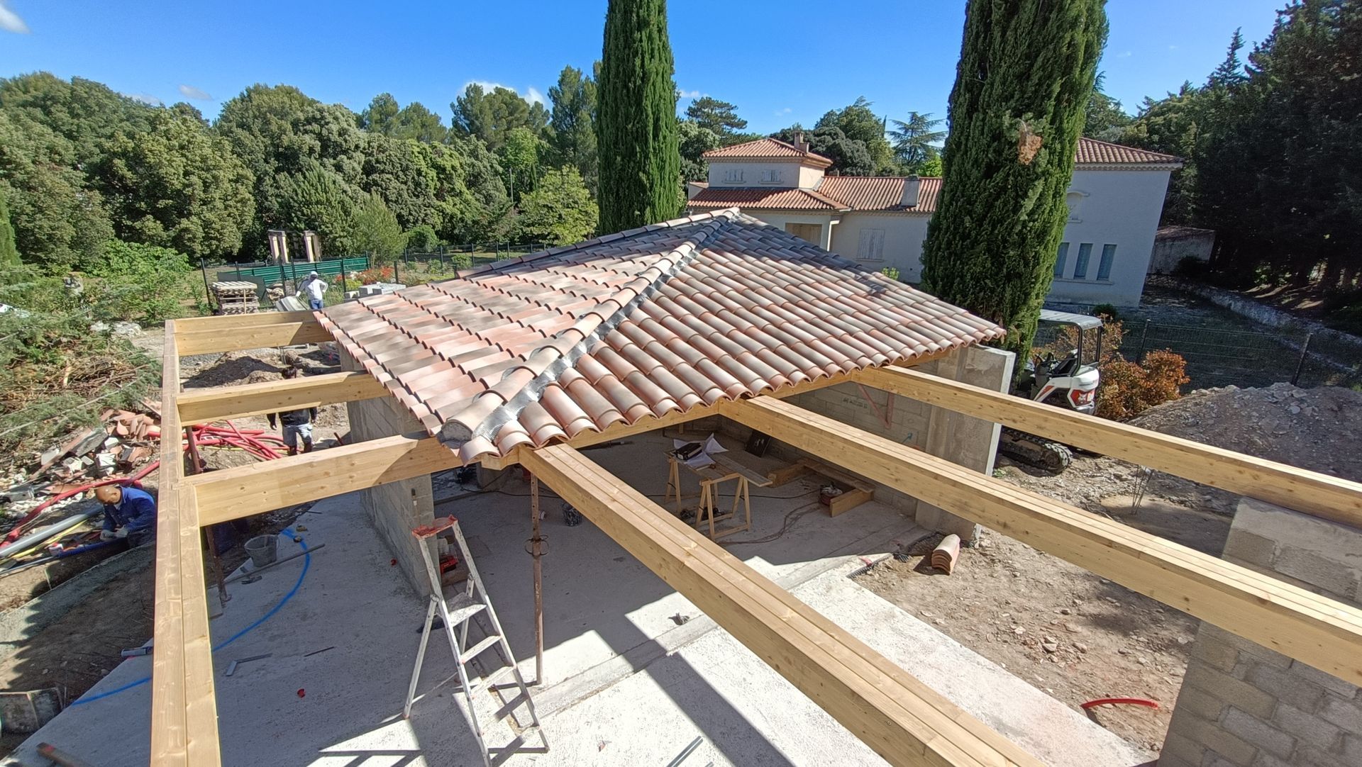 Une maison jaune avec des volets bleus aux fenêtres