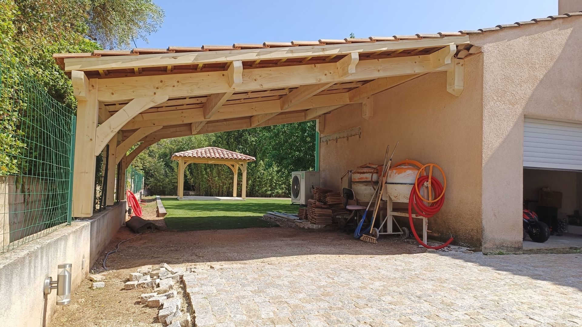 Une personne roule un rouleau d'asphalte sur un toit avec une torche.