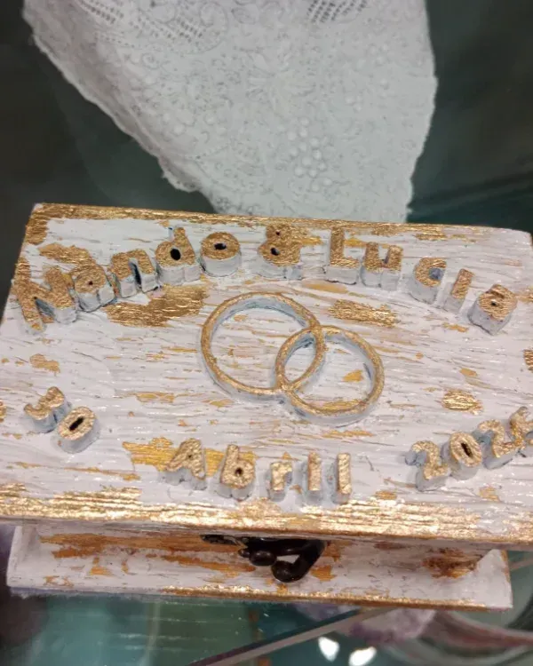 Placa de madera con letras doradas y anillos entrelazados, que conmemora una boda celebrada en 2012.