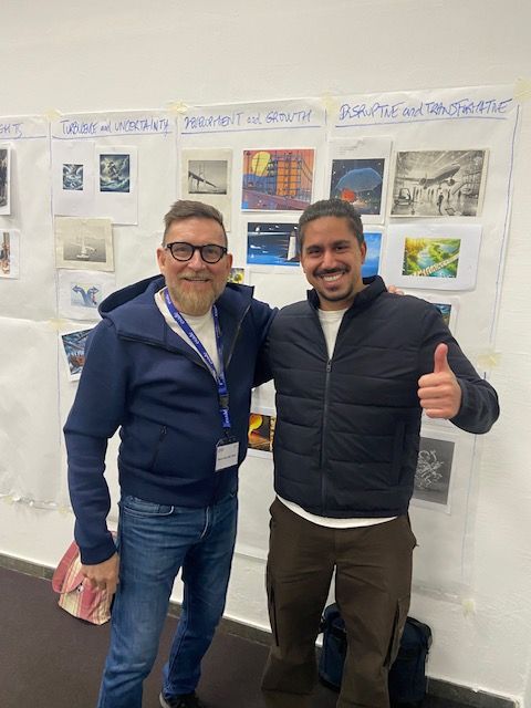 Dos hombres posan para una foto y uno levanta el pulgar.