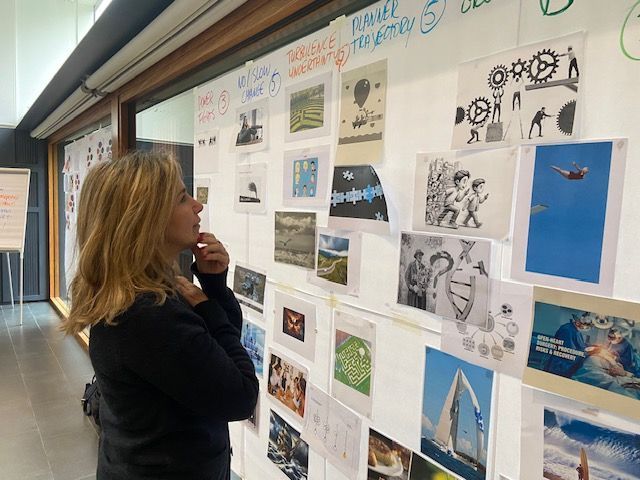 Una mujer está mirando cuadros en una pared.