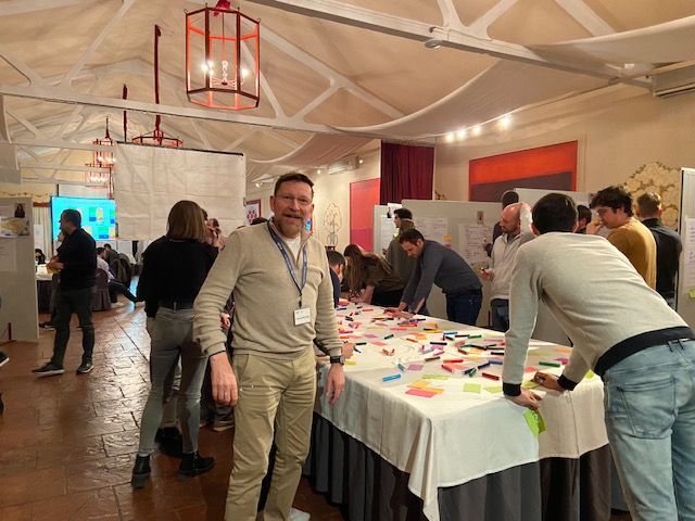 Un grupo de personas están de pie alrededor de una mesa con notas adhesivas sobre ella.