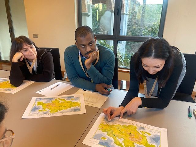 Un grupo de personas está sentada en una mesa mirando un mapa.