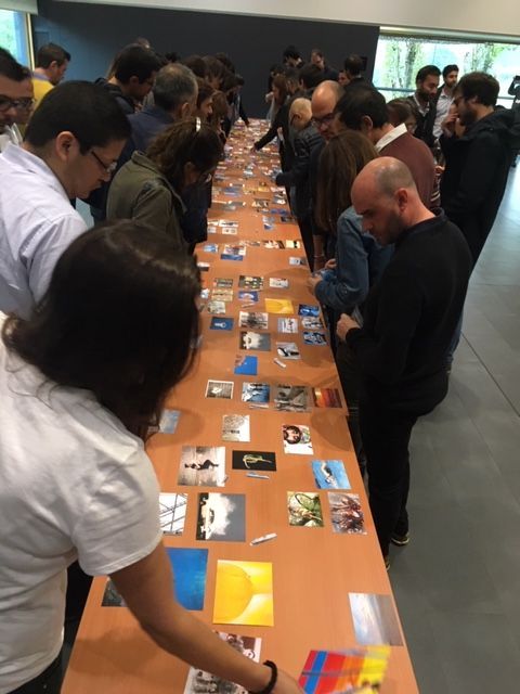 Un grupo de personas mira imágenes en una mesa larga.